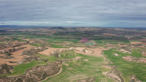 Luftaufnahme-Der-Ländlichen-Landschaft-Spaniens-Bewölkter-Tag,-Grüne-Felder-Und-Felsige-Hügel